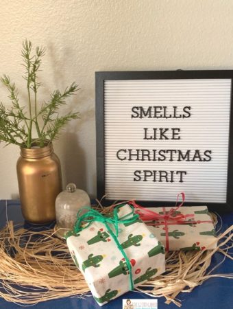 Christmas letter board quote with gifts and rosemary in a vase