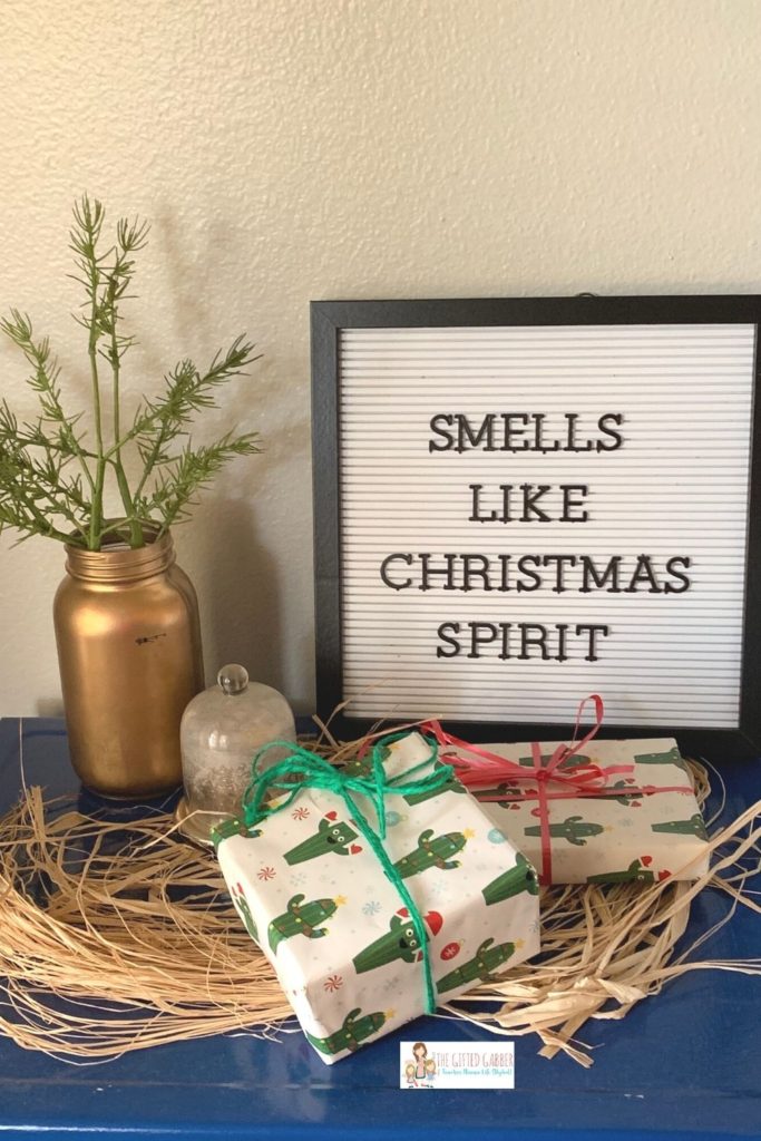 Christmas letter board quote with gifts and rosemary in a vase