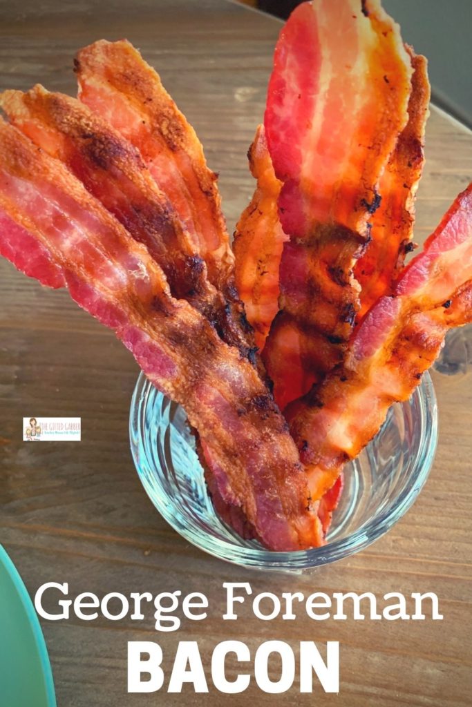 a glass of bacon grilled on George Foreman grill stands upright on a table