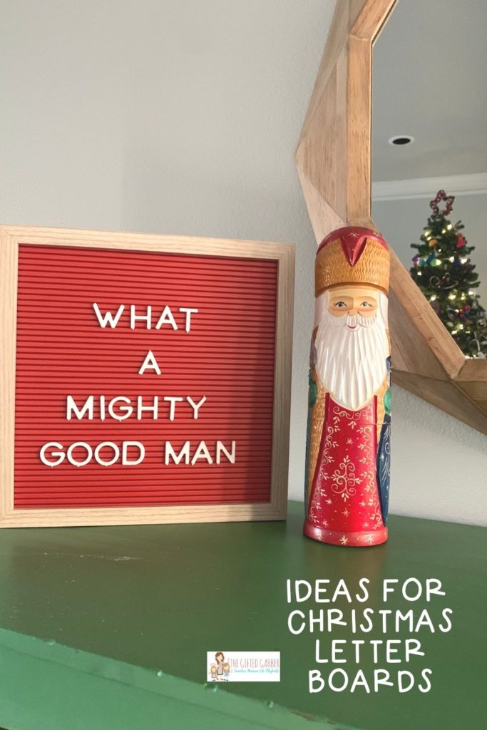 red letter board with short Christmas saying about Santa and a wooden carved Santa figurine