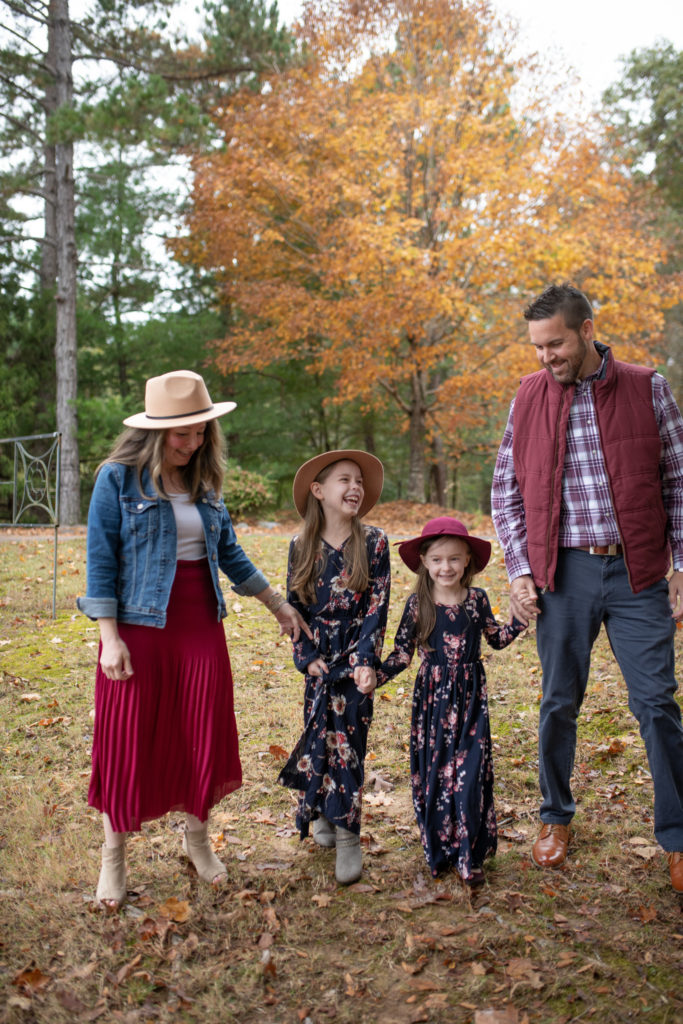 höstfamiljfotografering i Little Rock, Arkansas med familjen som går i koordinerande marinblå och burgundy outfits 