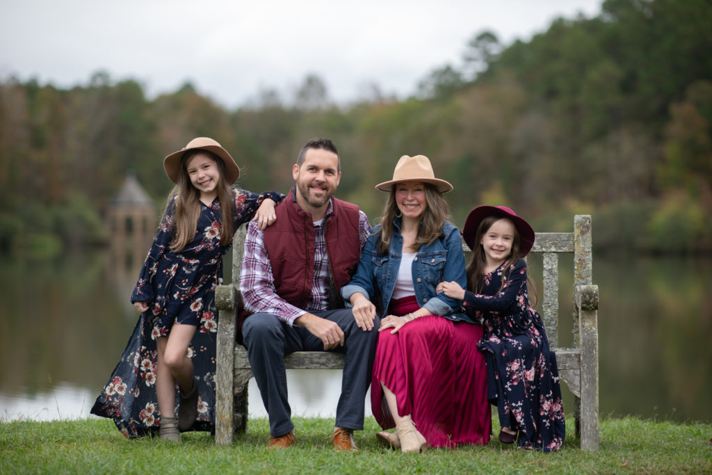 Familie posiert für Familienbilder in burgunder und blauen Outfits 