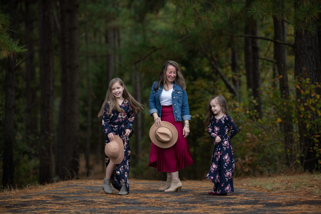 Arkansas blogger, Amy, of Planted in Arkansas and her two daughters twirl in twinning outfits at a Little Rock park