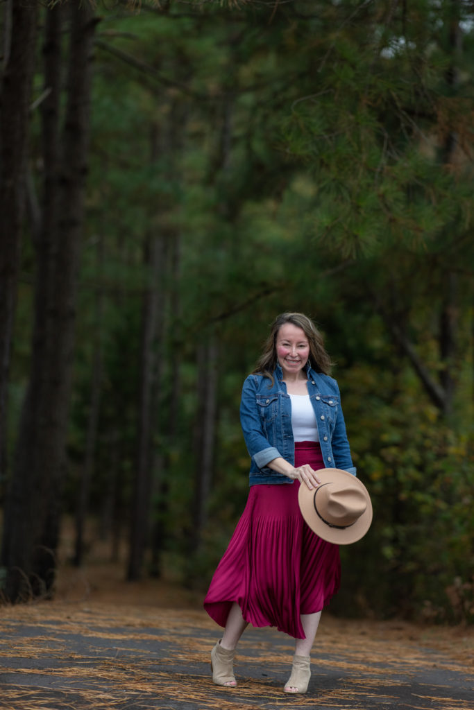  lady twirls en tenue bordeaux et bleue avec jupe midi plissée et chapeau de laine d'automne 