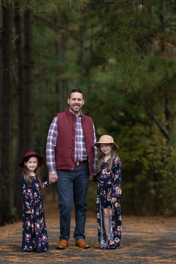Papa und Töchter Foto von Papa und Mädchen in marineblauen und burgunderroten Outfits