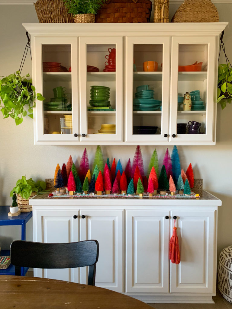 colorful bottle brush tree display on white cabinet in kitchen