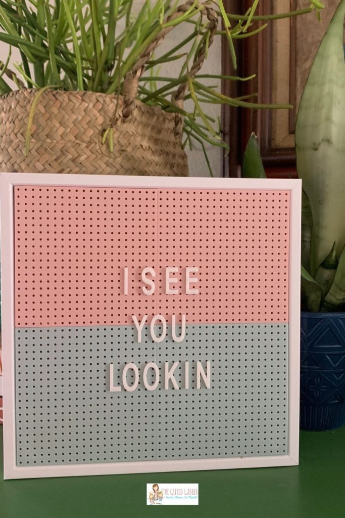 pink and green peg sign on green table with "I See You Lookin" quote