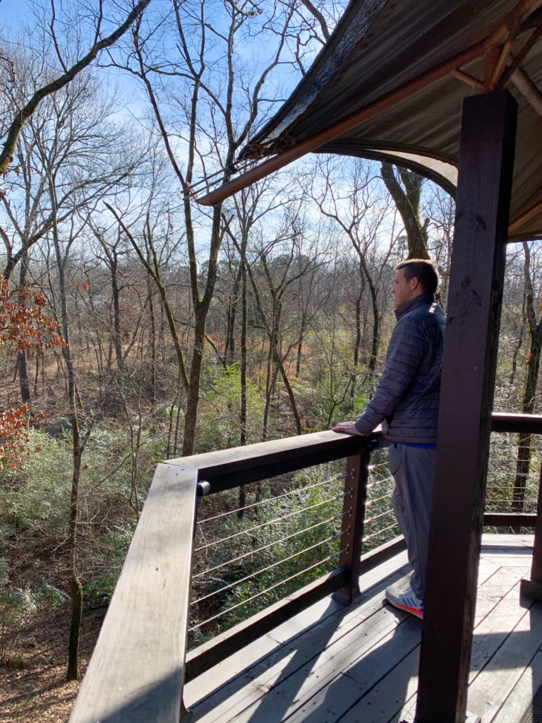 husband of Arkansas lifestyle blogger, Amy, explores nature off the deck of the Nest of Hot Springs luxury tent