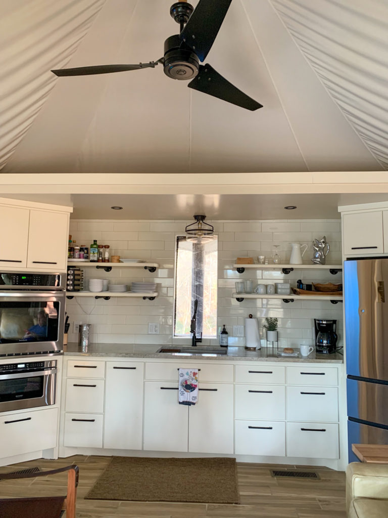 interior kitchen shot with white cabinets and stainless steel appliances inside a luxury tent in Hot Springs, Arkansas