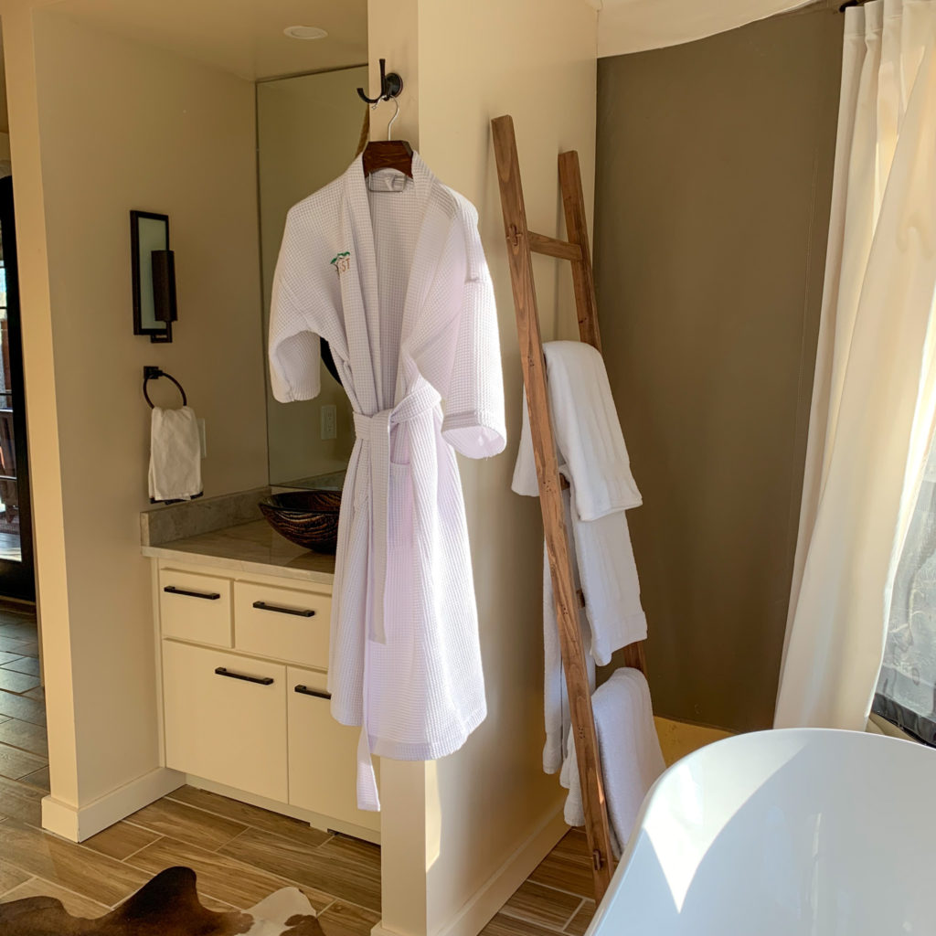 wooden blanket ladder with towels and white robe hang in luxury tent bathroom at the Nest in Hot Springs