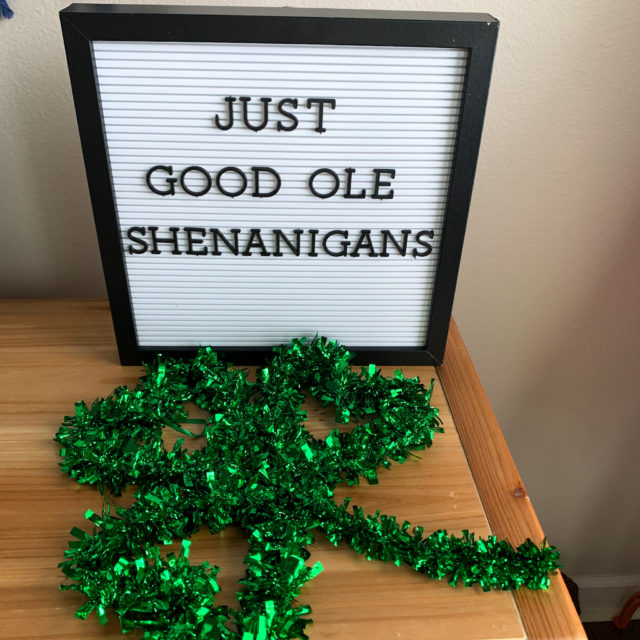 Shenanigans quote on St. Patrick's Day letter board with green shamrock decor in front