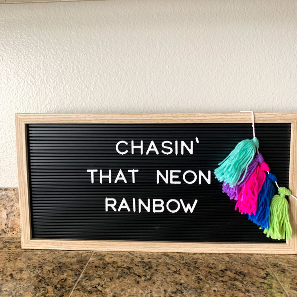 Rainbows quotes on black letterboard with rainbow tassle and Chasin that neon rainbow quote