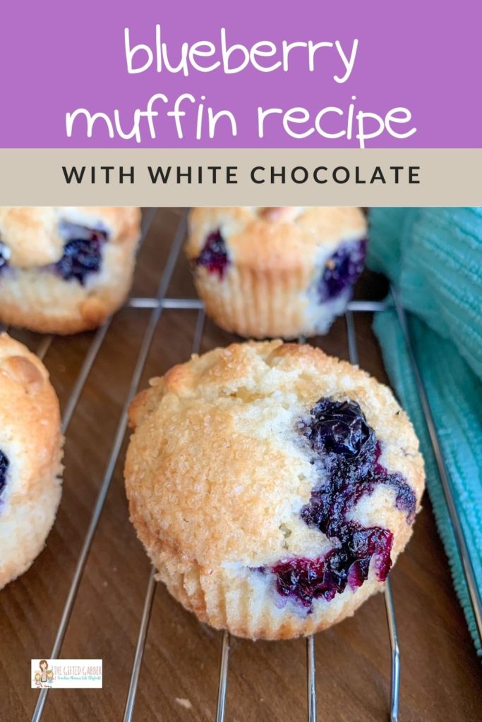 to die for blueberry muffins with white chocolate chips on wire rack with text overlay on top of image