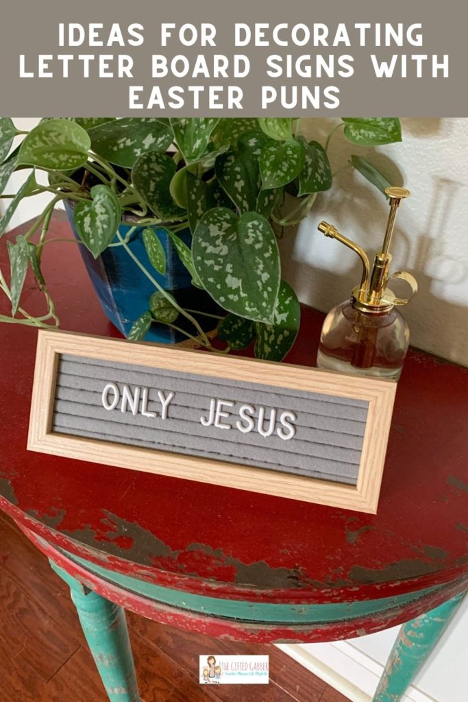 short Christian quotes on Easter on gray letter board in front of silver philodendron on red table
