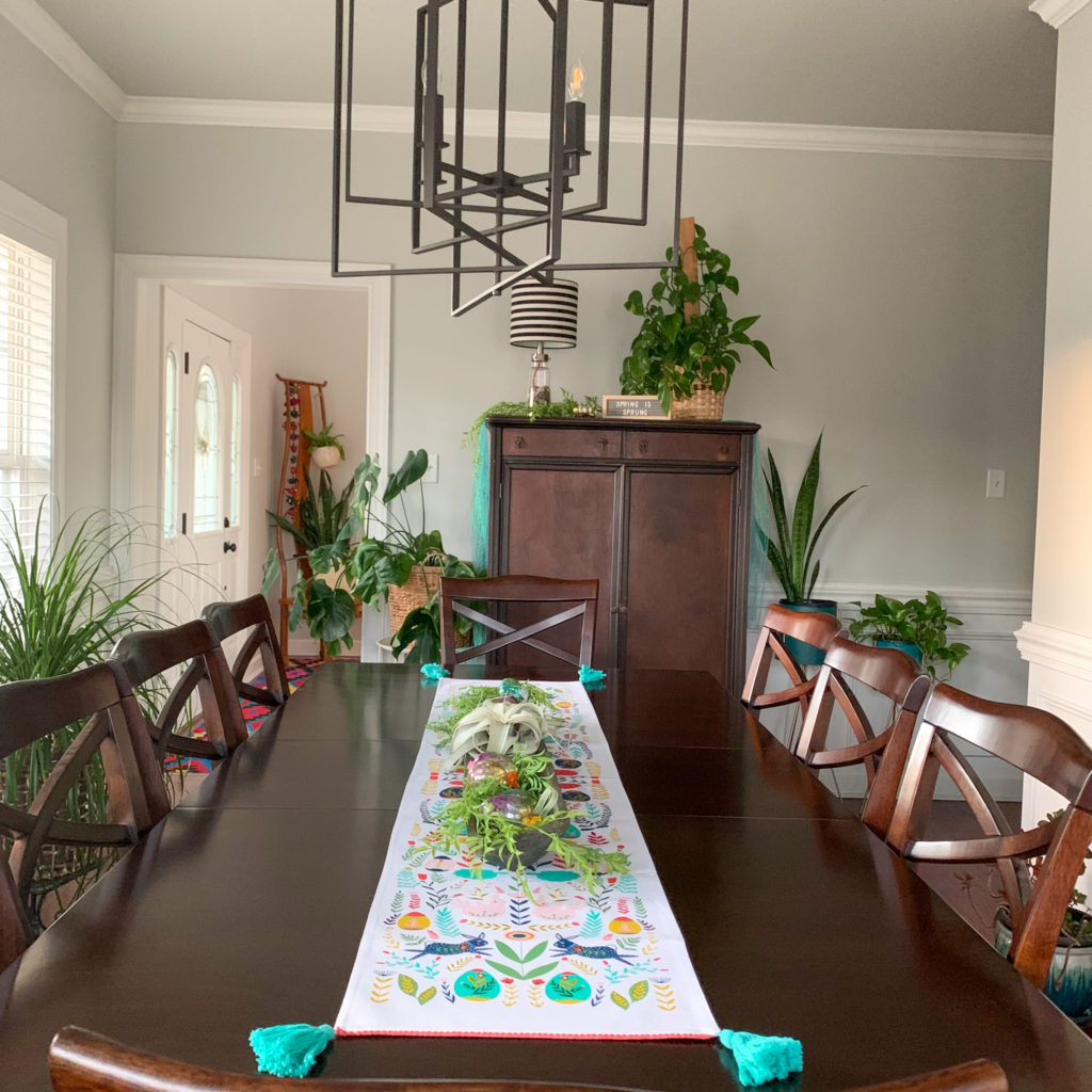 Boho Easter decor in dining room with simple Easter centerpiece and plants on wood table