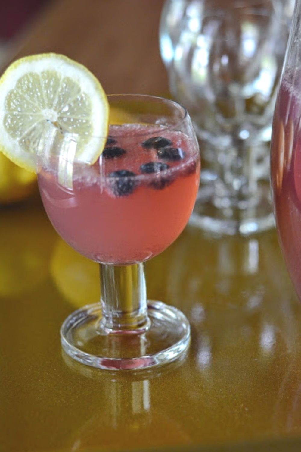 glass of Simply Blueberry Lemonade punch with prosecco and big lemon slice