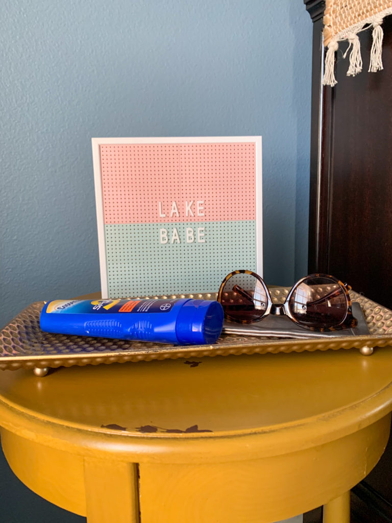 lake babe summer letter board on tray with sunscreen and sunglasses for inspiring beach quotes and cute camping quotes for Instagram