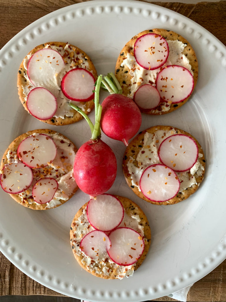 white plate with 5 cream cheese and crackers appetizers with Boursin and radishes 