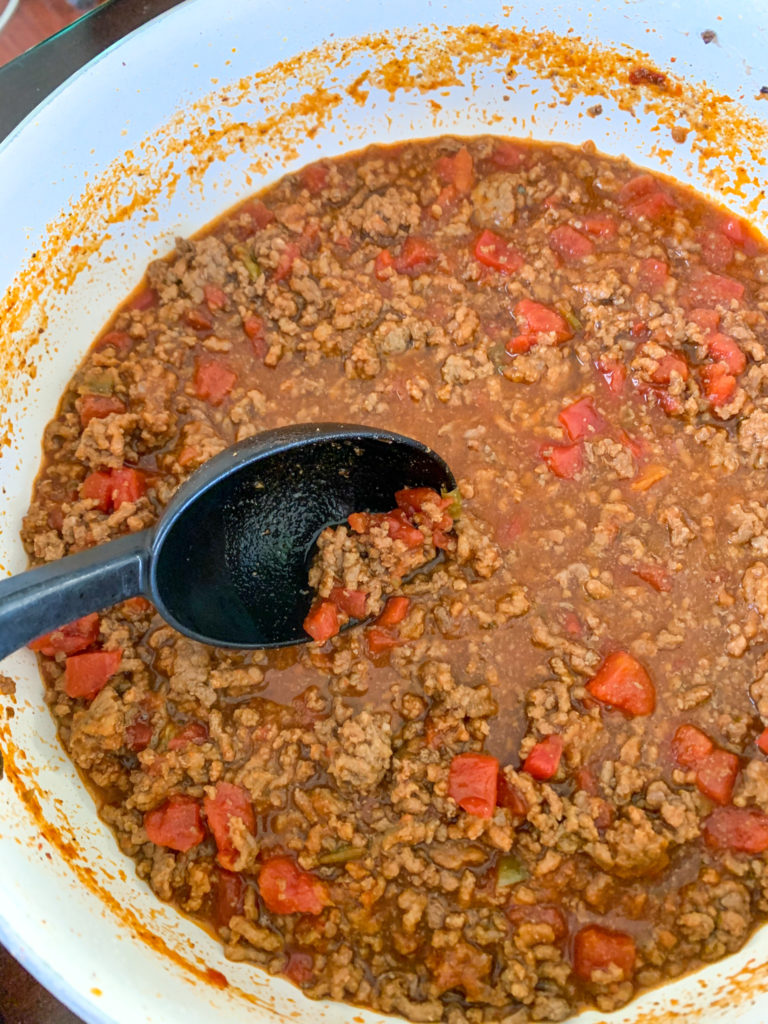 beanless chili in large white pot with serving spoon inserted
