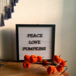 white letter board with fall letter board quotes and velvet pumpkins in front