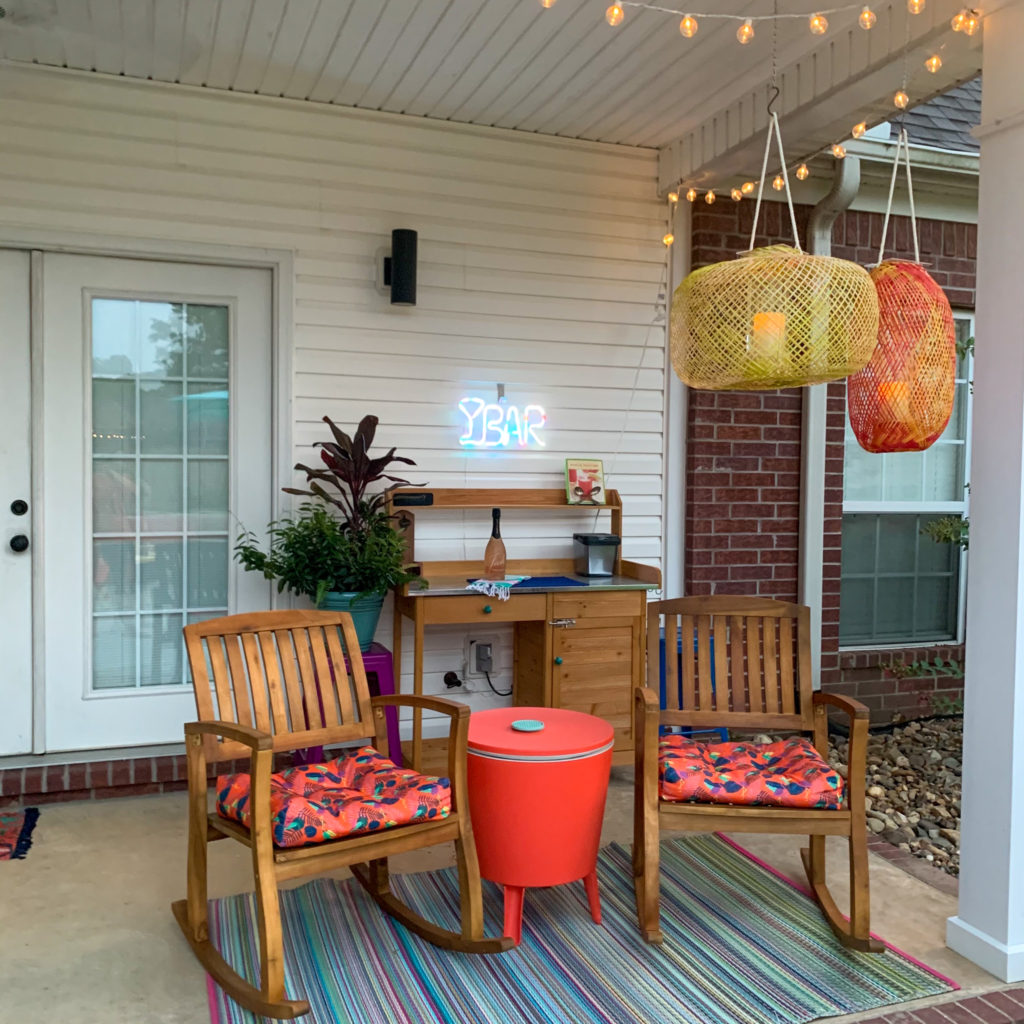 covered back porch tropical decor with outdoor rocking chairs, bamboo lanterns, Cancun outdoor rug and cooler table combo 