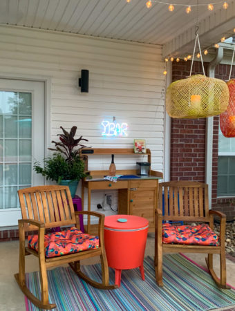covered porch and patio addition with modern boho patio decor like orange rocking chairs and and outdoor self serve bar cart