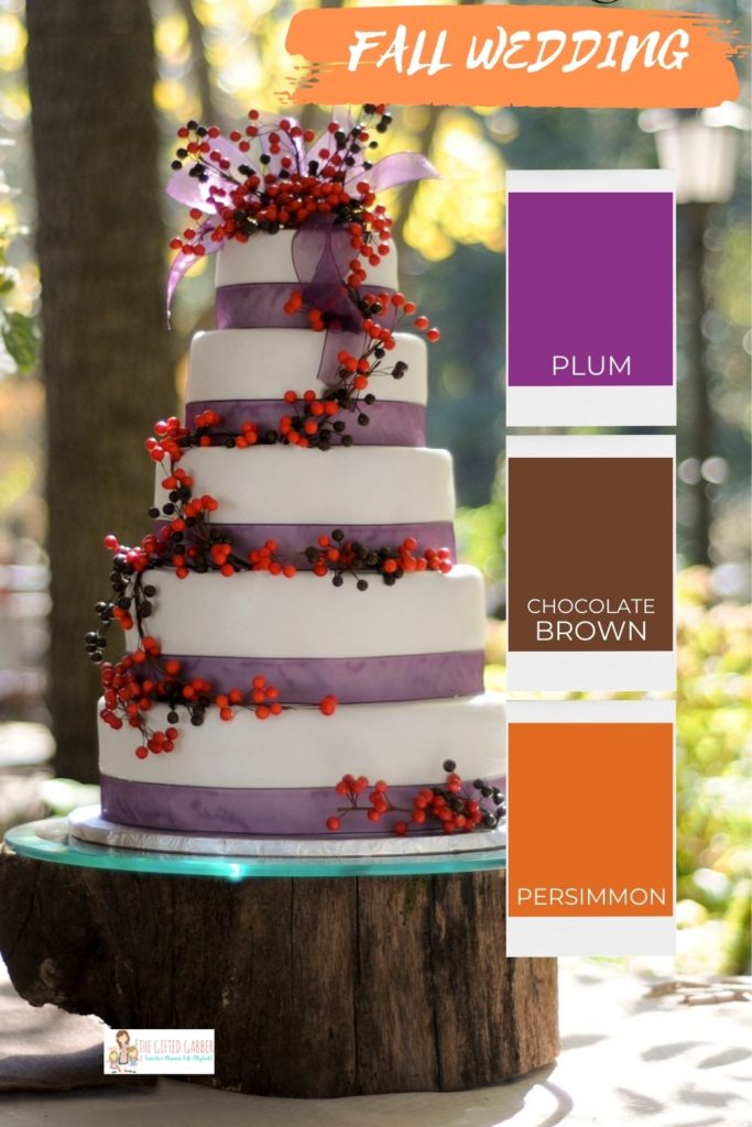 a five-layer wedding cake with berries and ribbon atop a thick wooden slab with a color palette chart