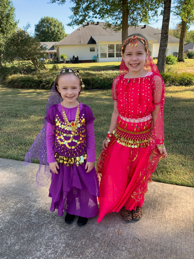 two little girls dressed in Halloween genie costumes - a purple and a pink costume
