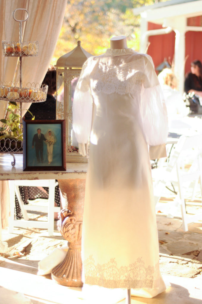 a mother's wedding dress on display at a fall wedding at Little Rock, Arkansas wedding venues, Alda's Magnolia Hill, beside a framed photo of the bride's parents on the table