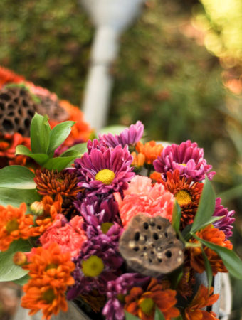 colorful fall bouquet with dried lotus petals and purple and orange Gerber daisies