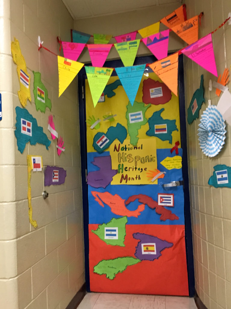 a classroom door decorated in flags and maps for Hispanic Heritage Month ideas for school 