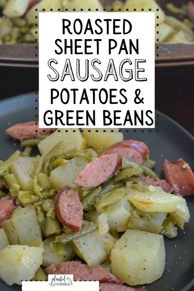 sausage potato green beans bake on a black plate with sheet pan in background