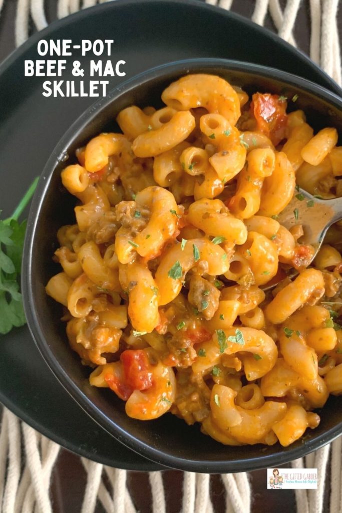 cheesy beef goulash in black bowl with text