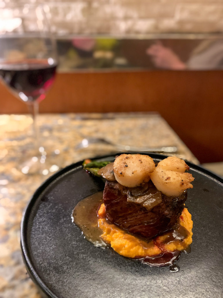 a steak and shrimp on black plate from Asador Restaurant 