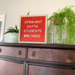 teachers retirement quotes on red letter board on wood armoire with plants
