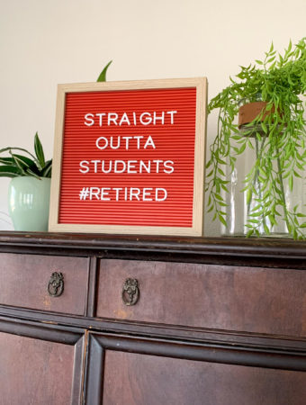 teachers retirement quotes on red letter board on wood armoire with plants