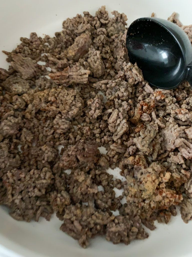 ground meat in skillet with black spoon