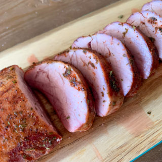 smoked pork tenderloin on wood platter