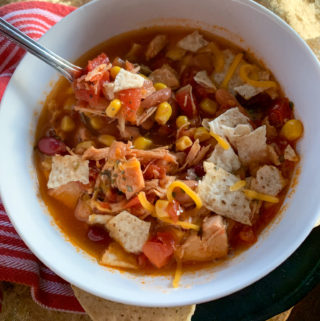 7 can chicken tortilla soup in white bowl with spoon
