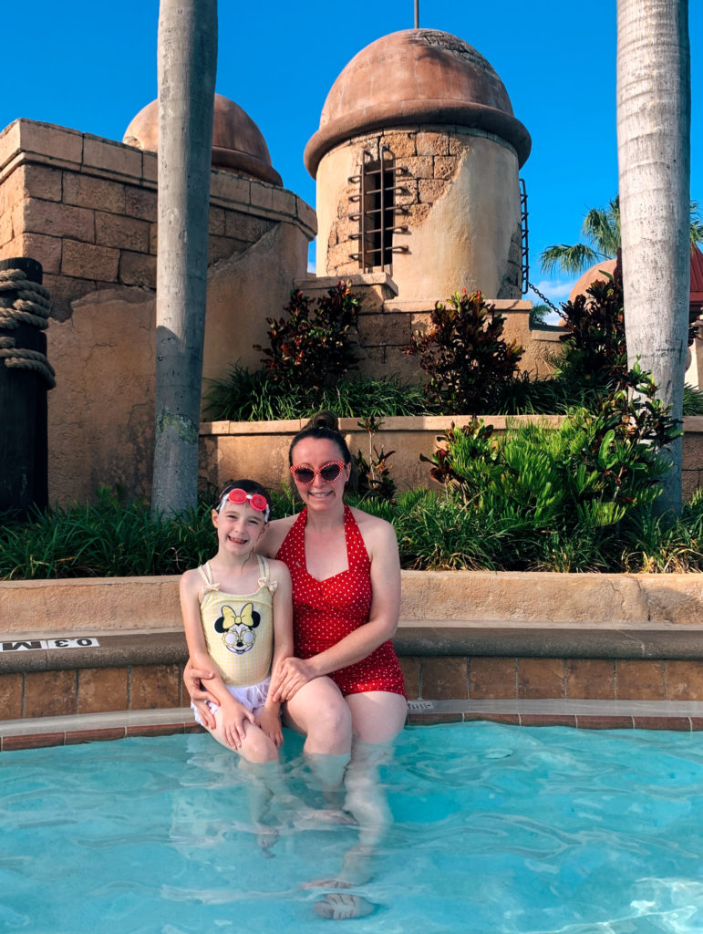 woman and child smile in Caribbean Beach Resort while showing Minnie inspired outfits for what to wear to Disney World