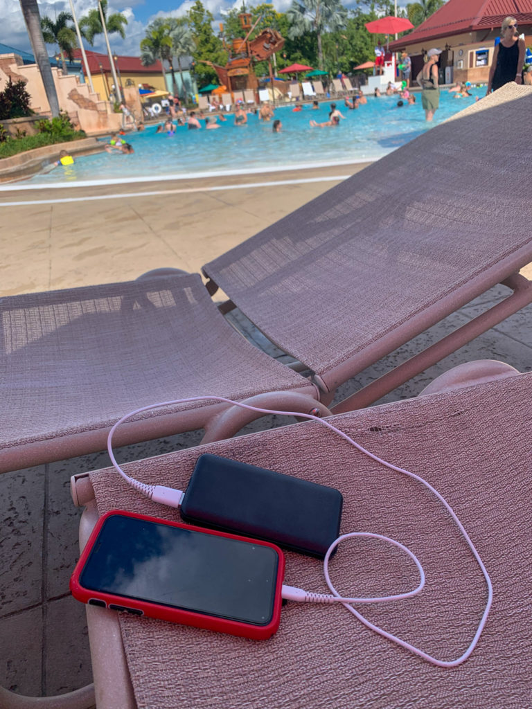 phone charging brick with red phone on pool lounge chair