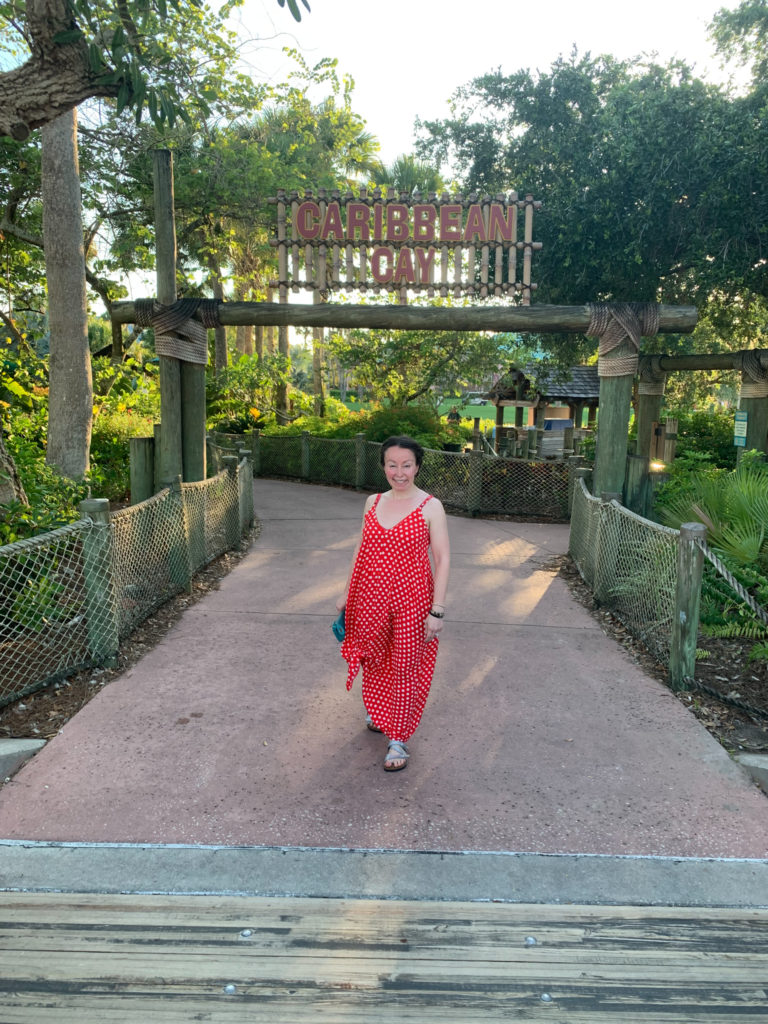 woman walks in Caribbean Beach Resort in red polka dot maxi dress for an idea on what to wear to Disney World