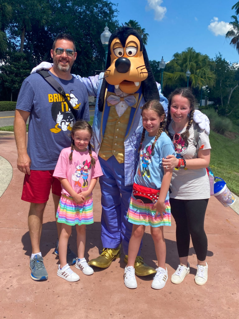 family poses for picture with Goofy in Caribbean Beach Resort