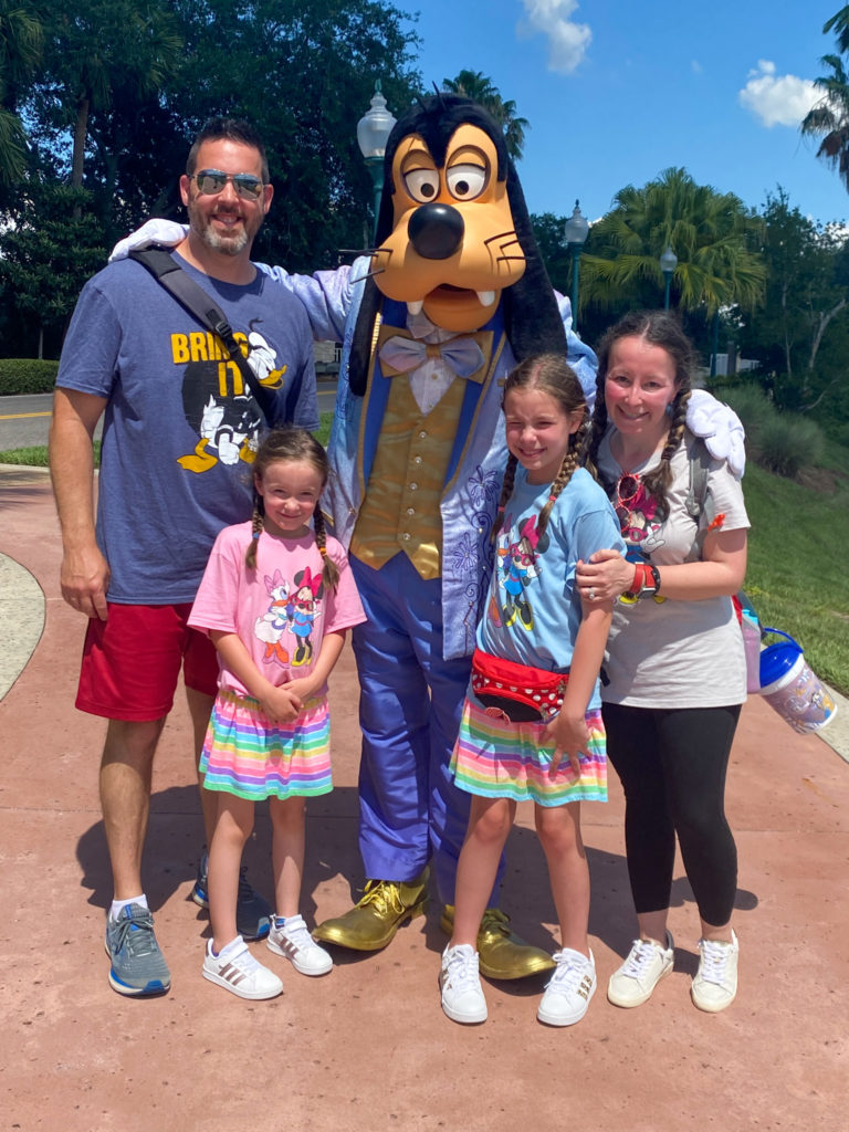 family posing with Goofy character at Disney World propery