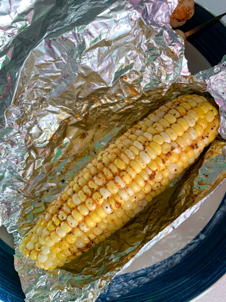 spicy corn on the cob grilled in foil on top of plate