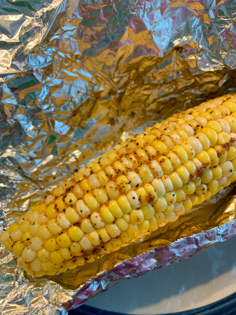beautiful corn grilled in foil on plate