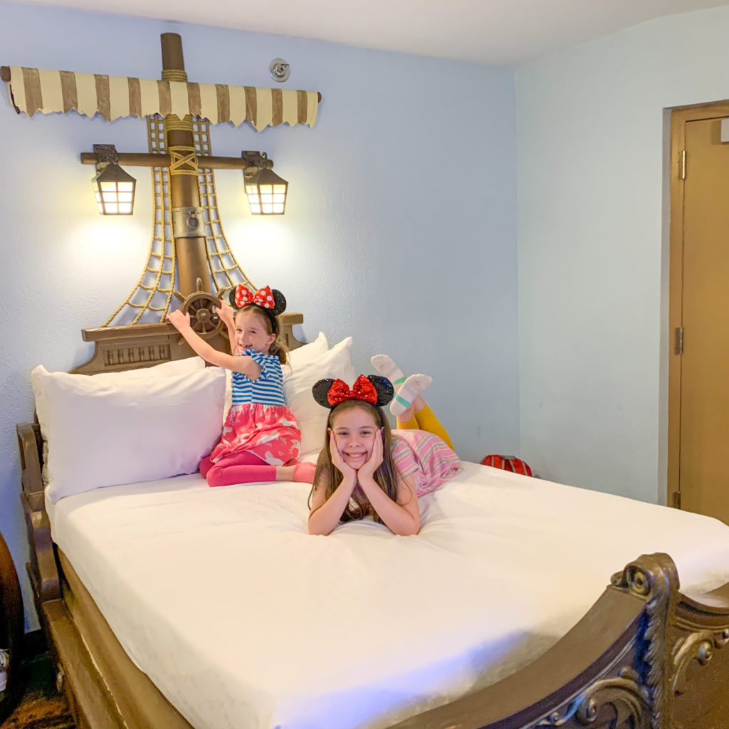 girls sitting on pirate bed in a Disney Caribbean Beach Resort pirate room