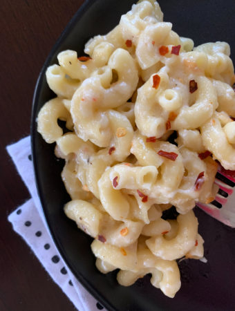 pepper jack macaroni and cheese on black plate atop polka dot napkin