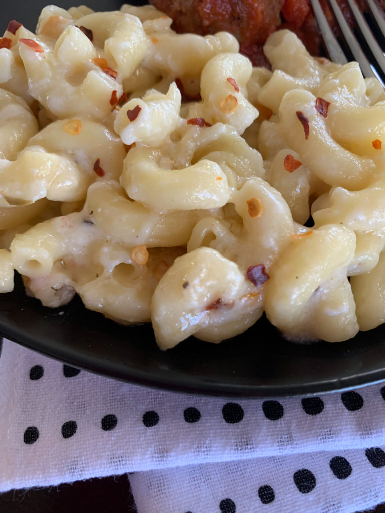 pepper jack mac and cheese on black plate with polka dot napkin under