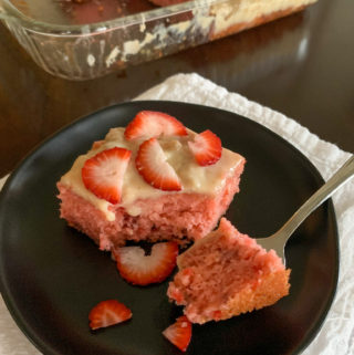 strawberry banana cake slice with fork on black plate